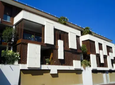 Terrasse et balcon d'une résidence aménagés avec des brise-soleil orientable à volet coulissant et panneau de séparation fixe