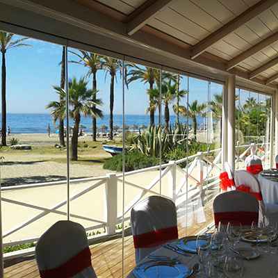 Fermeture d'une terrasse de restaurant en bord de plage avec une cloison vitrée extérieure