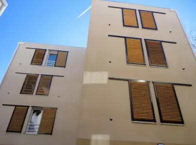 Brise-soleil orientable extérieur en façade d'immeuble pour porte-fenêtre avec balustrade nécessilant un volet coulissant